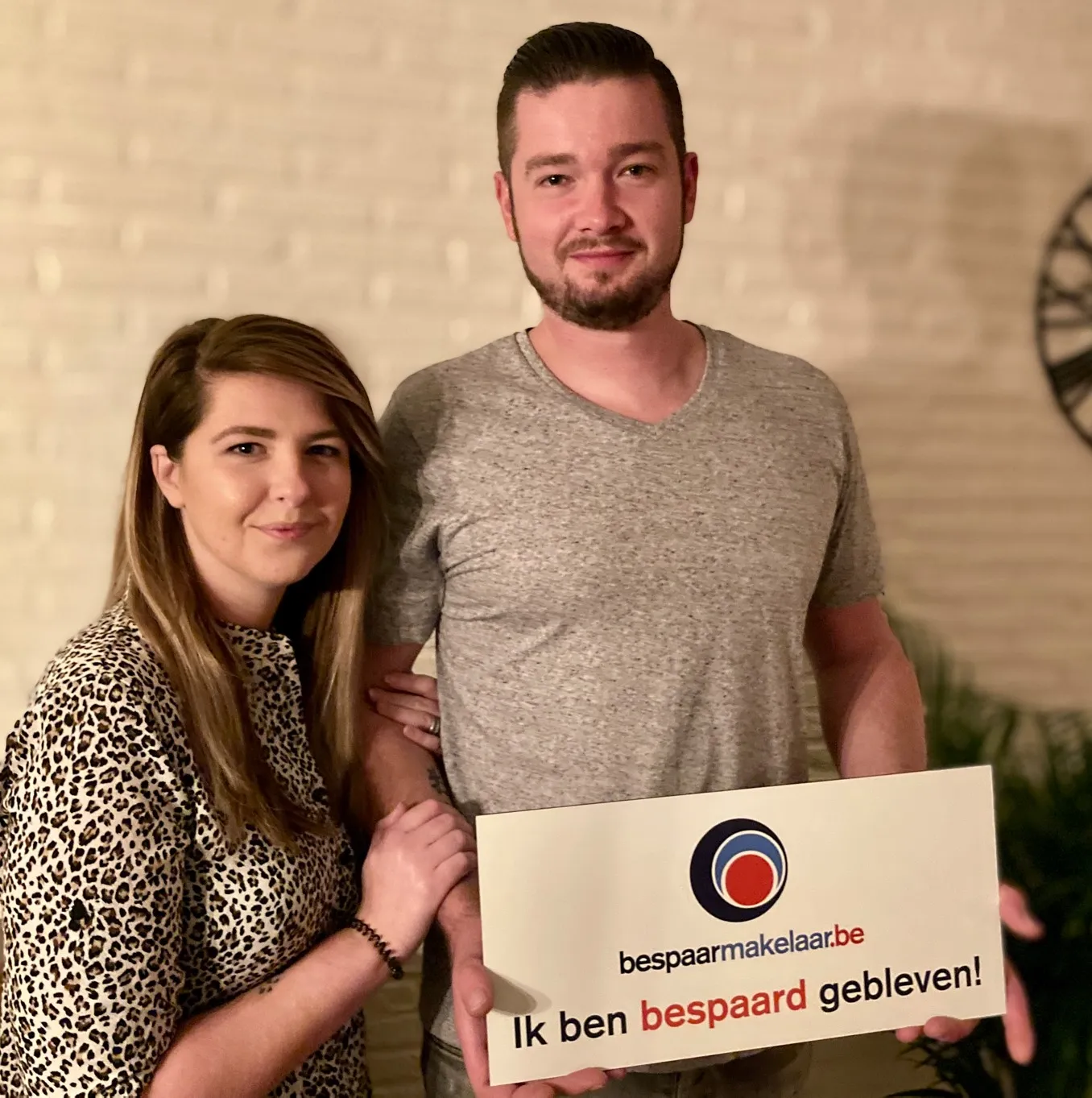 Jong koppel met het bordje 'Ik ben bespaard gebleven!'
