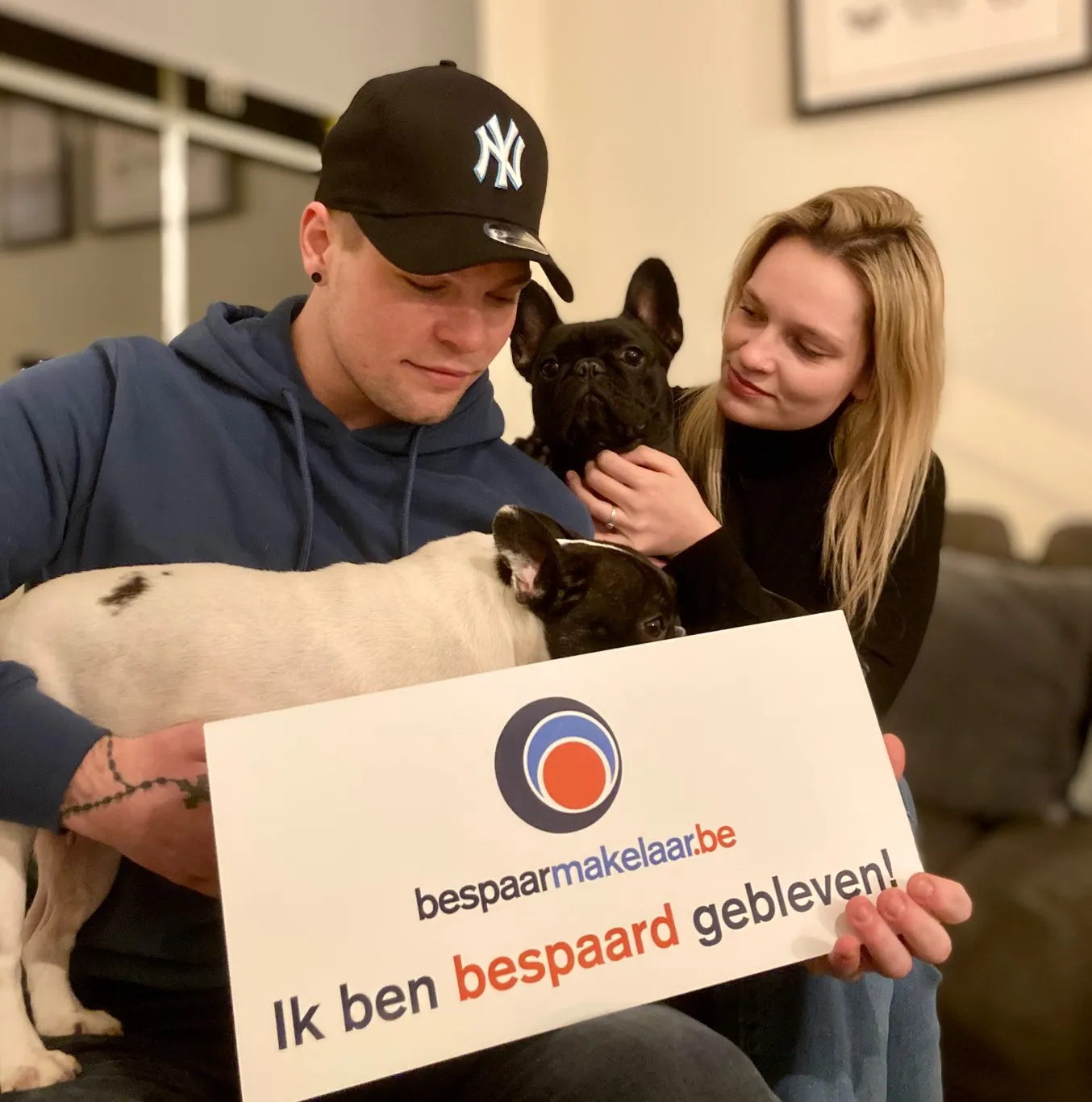 Koppel met hun hond met het bordje 'Ik ben bespaard gebleven!'